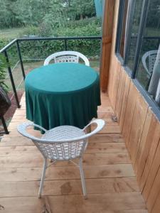 a table and chairs on a porch with a green table at Lux tree house karen in Nairobi