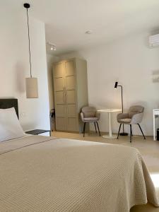 a bedroom with a bed and two chairs and a table at Residenza Marrone in Montefalco