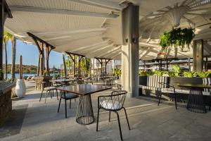 a restaurant with tables and chairs on a patio at Shandrani Beachcomber Resort & Spa in Blue Bay