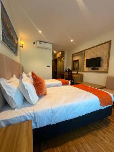 a hotel room with two beds and a television at Hotel Eleven in Kathmandu