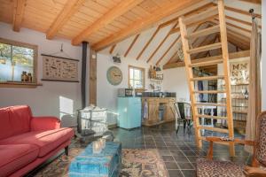 a living room with a red couch and a kitchen at Schaapskooi in Maarsbergen