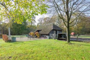 a barn in a field with a horse in the background at Schaapskooi in Maarsbergen