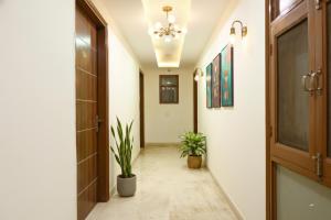 a hallway with two potted plants and a door at Hotel HSP Suites - Near IGI Airport, New Delhi in New Delhi