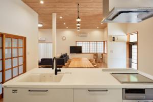 a kitchen with a sink and a living room at 修善寺あざみ Luxury Japanese Villa with Mt Fuji Views and Onsen in Izu