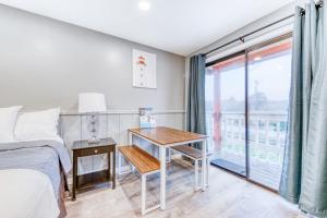a bedroom with a bed and a desk and a window at Sea Treasures Inn Unit #212 in Rockaway Beach