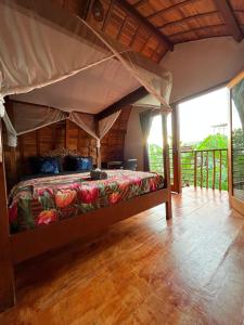 a bedroom with a bed with a canopy at Ayolah surf House and Surfcamp in Jembrana