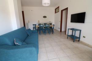 a living room with a blue couch and a table at Casa Giselle in Otranto in Otranto