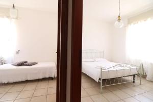 two beds in a room with white walls at Casa Giselle in Otranto in Otranto