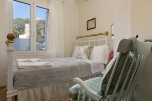 a bedroom with a bed and a chair and a window at Athenais Two Storey House in Zakynthos