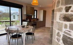 a kitchen and dining room with a table and chairs at MOULIN DE KERNOT in Cléden-Cap-Sizun