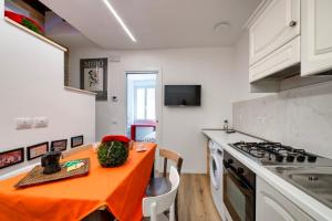 a kitchen with an orange table and a stove at Torretta In Centro Perugia in Perugia