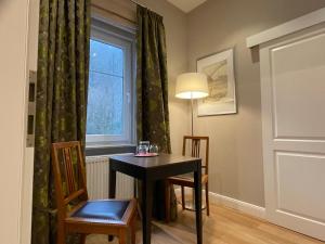 a dining room with a table and chairs and a window at Villa Waldfrieden - Design trifft Budget in Annweiler am Trifels