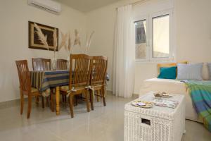 a living room with a table and chairs and a bed at Athenais Two Storey House in Zakynthos