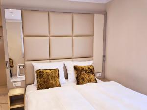 a bedroom with a large white bed with two pillows at Boutique Hotel am Bodensee in Friedrichshafen
