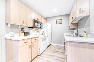 a kitchen with white appliances and wooden cabinets at Sea Treasures Inn Unit #212 in Rockaway Beach