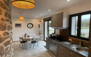a kitchen with a table and a dining room at MOULIN DE KERNOT in Cléden-Cap-Sizun