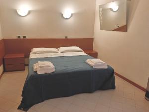 a bedroom with a bed with two towels on it at Affittacamere San Cristoforo Faenza in Faenza