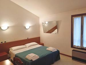 a bedroom with a bed with two towels on it at Affittacamere San Cristoforo Faenza in Faenza