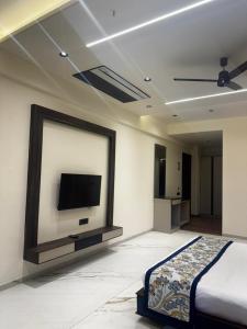 a bedroom with a bed and a tv on the wall at Lords Swastik Studio Kodinar in Kodīnar