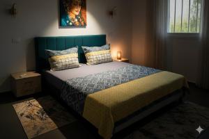 a bedroom with a large bed with a green headboard at Villa Mabrouka in Raʼs al Jabal +62 photos
