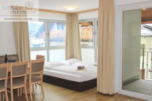 a bedroom with a bed and a table and chairs at Alpenperle in Ischgl
