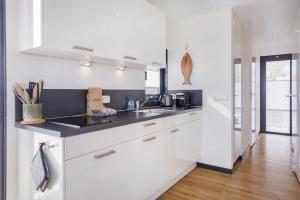 a kitchen with white cabinets and a sink at Welcome in - Houseboat Agua Dolce met tuin, Paviljoenwei 4, Sneek - Offingawier in Offingawier +69 photos