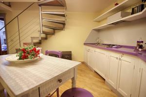 a kitchen with a table with a vase of flowers on it at Rinidia Siena Centro in Siena