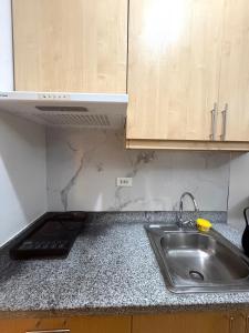 a kitchen counter with a sink and wooden cabinets at Compact Studio Unit At Mesaverte Residences in Pontud