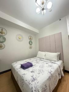 a bedroom with a bed with a purple pillow on it at Compact Studio Unit At Mesaverte Residences in Pontud