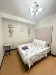 a bedroom with a bed and a chandelier at Compact Studio Unit At Mesaverte Residences in Pontud