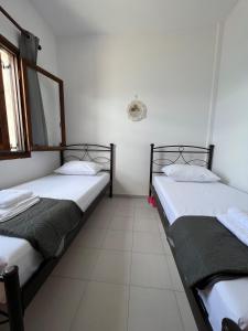 two twin beds in a room with a window at Beachfront summer house in Derveni