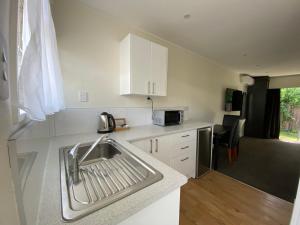 a kitchen with a sink and a microwave at Paraparaumu Motel in Paraparaumu