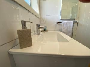a bathroom sink with a faucet and a mirror at Paraparaumu Motel in Paraparaumu