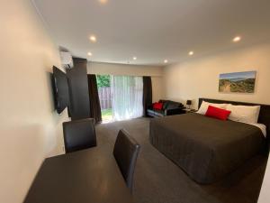 a hotel room with a bed and a table and chairs at Paraparaumu Motel in Paraparaumu