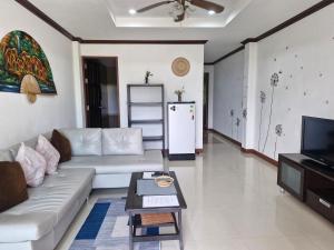 a living room with a white couch and a refrigerator at BEA Privileged Apartment in Lamai