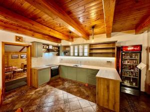 a large kitchen with wooden ceilings and a counter top at Penzion pod Šerákem in Ostružná