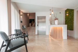 a lobby with chairs and a table and stairs at Hotel Restaurant Kod Barića in Grude