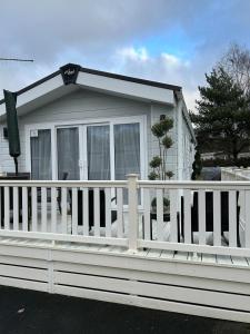 a white fence in front of a house at Tulip 10, Oakdene Forest Park , passes included in Saint Leonards