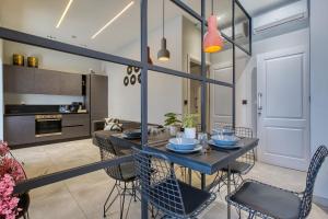 a kitchen and dining room with a table and chairs at Stylish 1-Bedroom Apartment Just 5 Minutes from Valletta by Ferry in Mosta