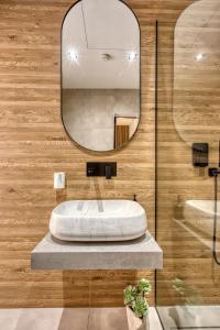 a bathroom with a round sink and a mirror at Stylish 1-Bedroom Apartment Just 5 Minutes from Valletta by Ferry in Mosta +27 photos