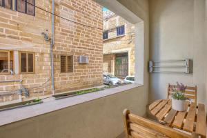 a window in a room with a bench and a table at Stylish 1-Bedroom Apartment Just 5 Minutes from Valletta by Ferry in Mosta