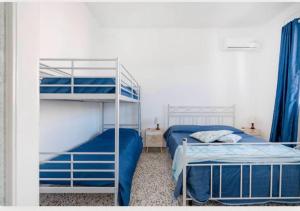 a bedroom with two bunk beds with blue sheets at Residenza Marittima in Torre Canne