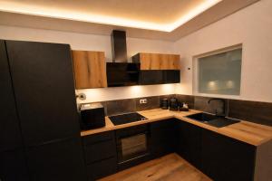a kitchen with wooden cabinets and a counter top at ZEN SPA-4 Pers-Jacuzzi-Parking-Clim-Colmar in Colmar