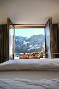 a bedroom with a large bed with a mountain view at Alpencabin Montafon in Vandans