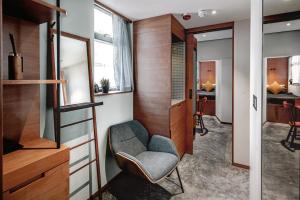 a small room with a chair and a bedroom at Oootopia Kai Tak in Hong Kong +4 photos