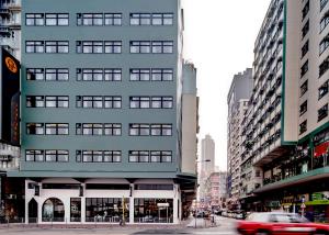a tall gray building on a city street with cars at Oootopia Kai Tak in Hong Kong