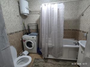 a bathroom with a toilet and a washing machine at Бухар жырау 45 in Karagandy