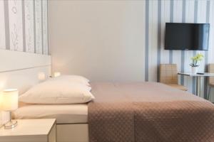 a bedroom with a bed and a tv on the wall at Boutique Hotel am Bodensee in Friedrichshafen +11 photos