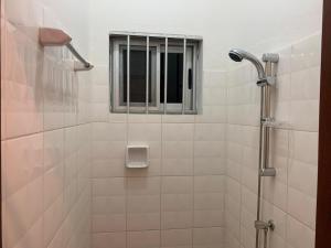 a shower with a window in a bathroom at Appartement - BIOKOU - Route des pêches in Cotonou