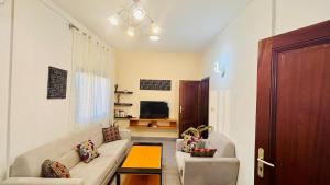 a living room with a couch and a tv at Appartement - BIOKOU - Route des pêches in Cotonou